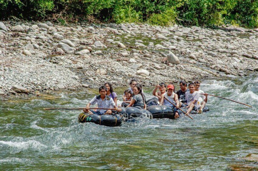 A group of people rafting down a river surrounded by rocks and greenery. 4
