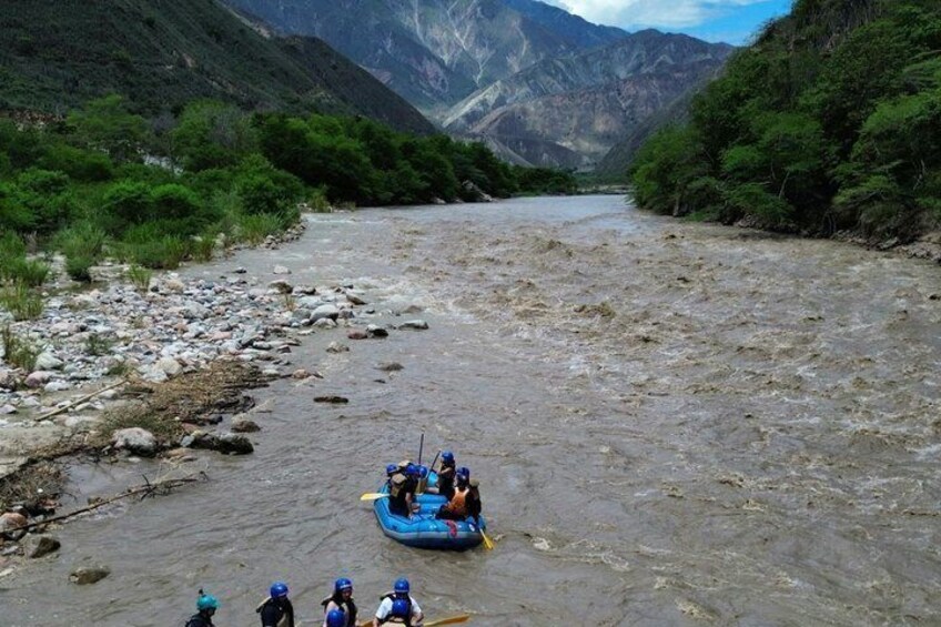 A group of people rafting down a river surrounded by mountains. 3