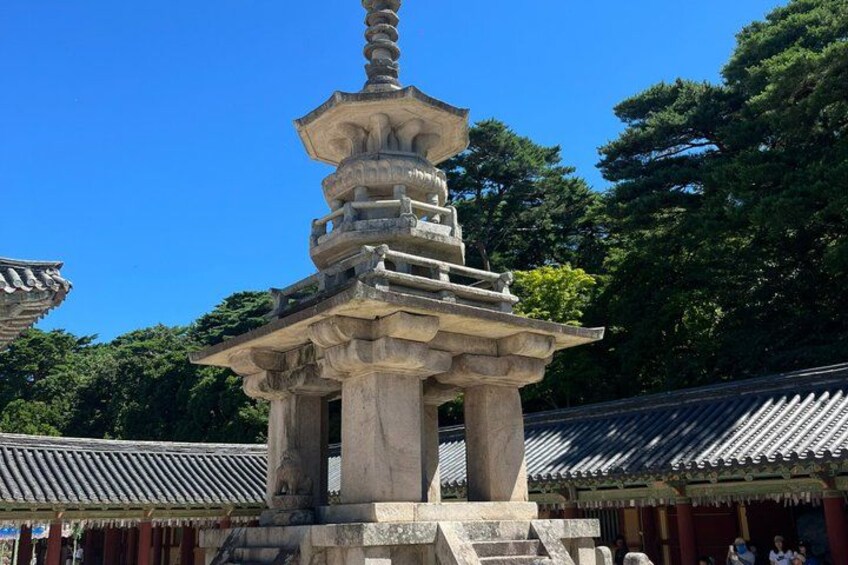 A traditional Japanese pagoda with multiple tiers, surrounded by trees and traditional architecture. 2