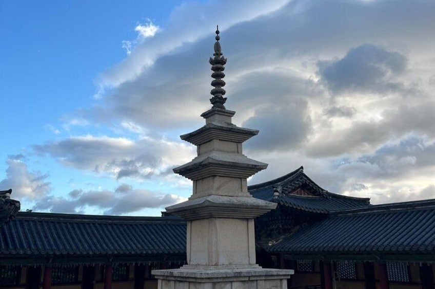 Une pagode traditionnelle à plusieurs niveaux, entourée d’édifices représentatifs de l’architecture coréenne traditionnelle. 1