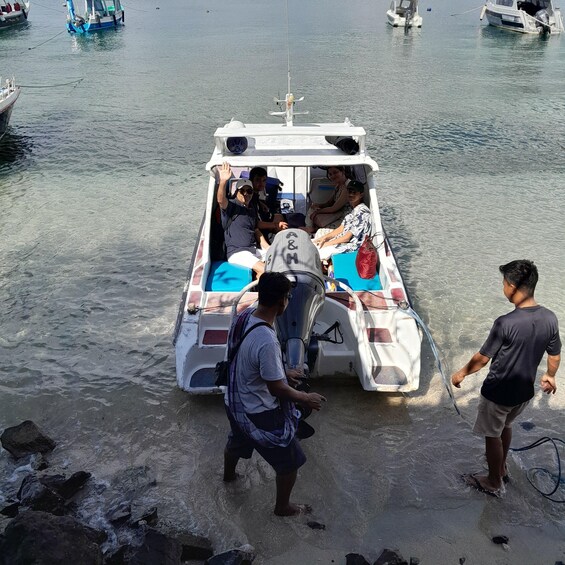 A small boat with passengers, a rocky shoreline, and other boats in the background. 4
