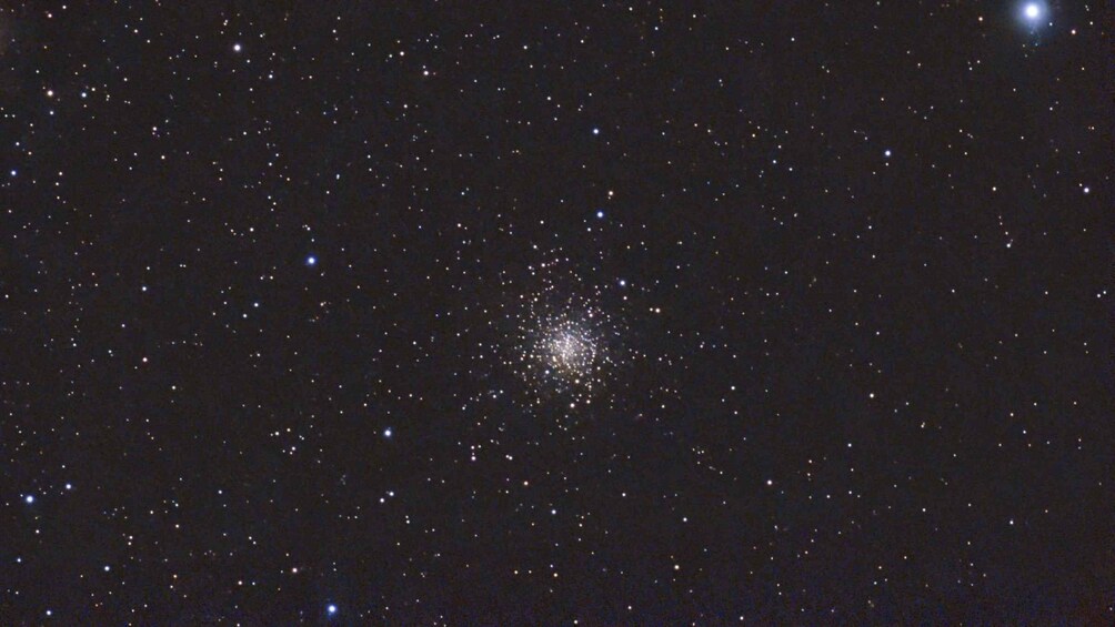 A starry night sky with a dense cluster of stars and a bright star in the upper right corner. 5