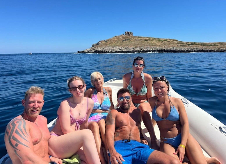 A group of people on a boat with a rocky island in the background. 1