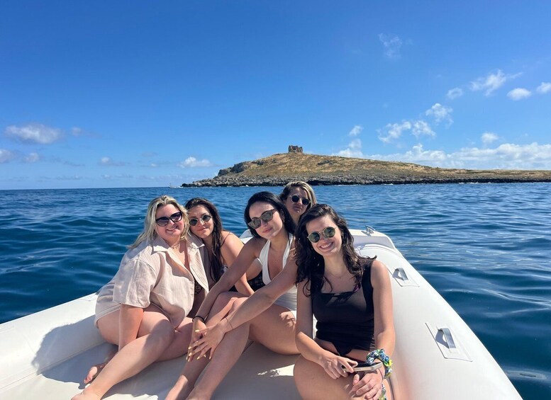 A group of people on a boat with a rocky island and a castle in the background. 5