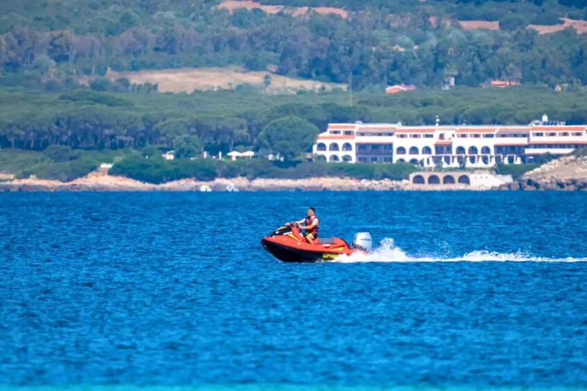 A person jet-skiing on a body of water with a large building in the background. 5