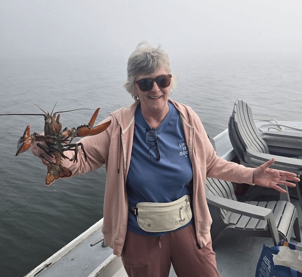 A person holding a lobster on a boat. 5