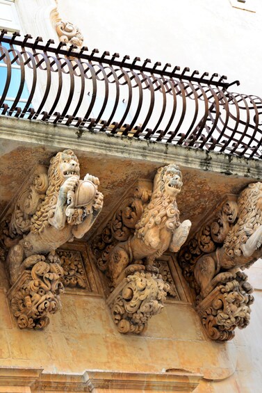 Ornate stone carvings of lions on a building's facade. 4