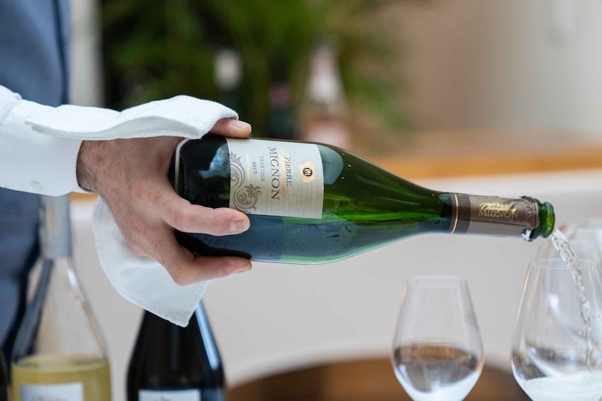 A person pouring champagne from a bottle into glasses. 3