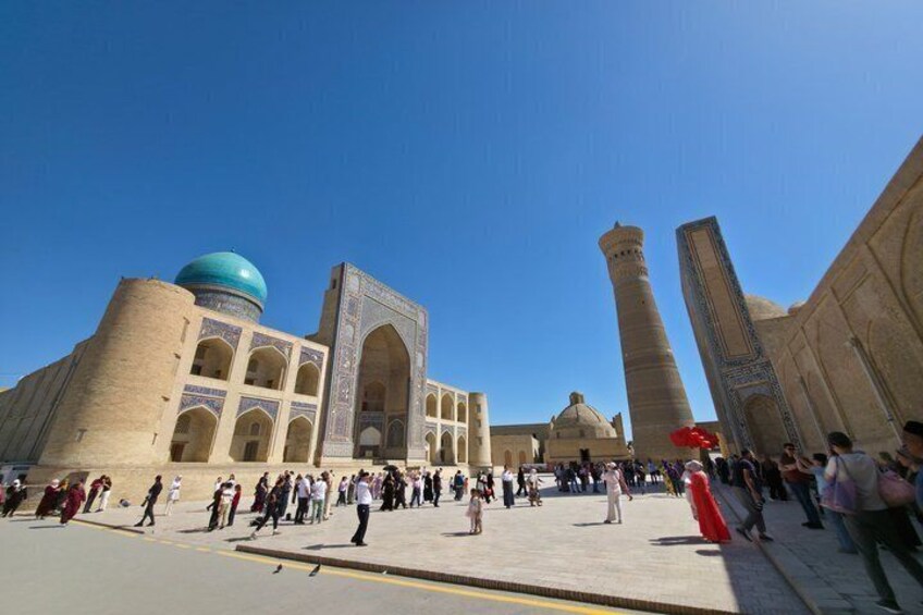 A large historical building with a prominent dome and minarets, surrounded by a crowd of people. 4