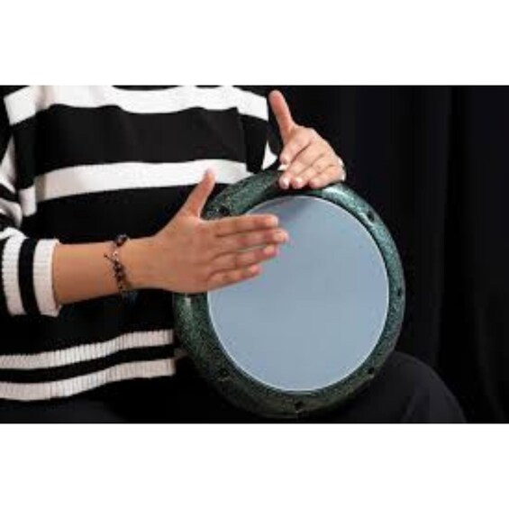 A person holding a round, green tambourine. 5