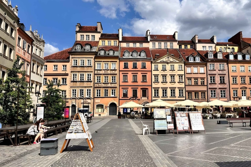A European square with colorful historic buildings, outdoor seating, and art displays. 2
