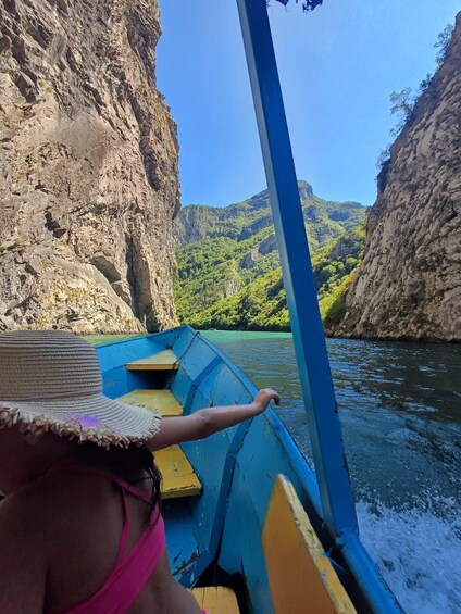 A boat navigating a narrow river surrounded by steep cliffs. 2