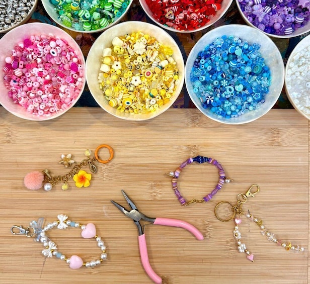 Various beads and jewelry-making tools on a wooden surface. 1
