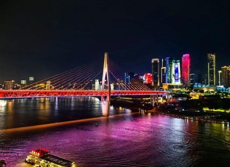 A nighttime cityscape with a prominent red bridge over a river, illuminated buildings, and a boat on the water. 4