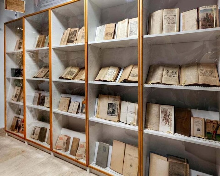 A display of old books in glass-fronted shelves. 5