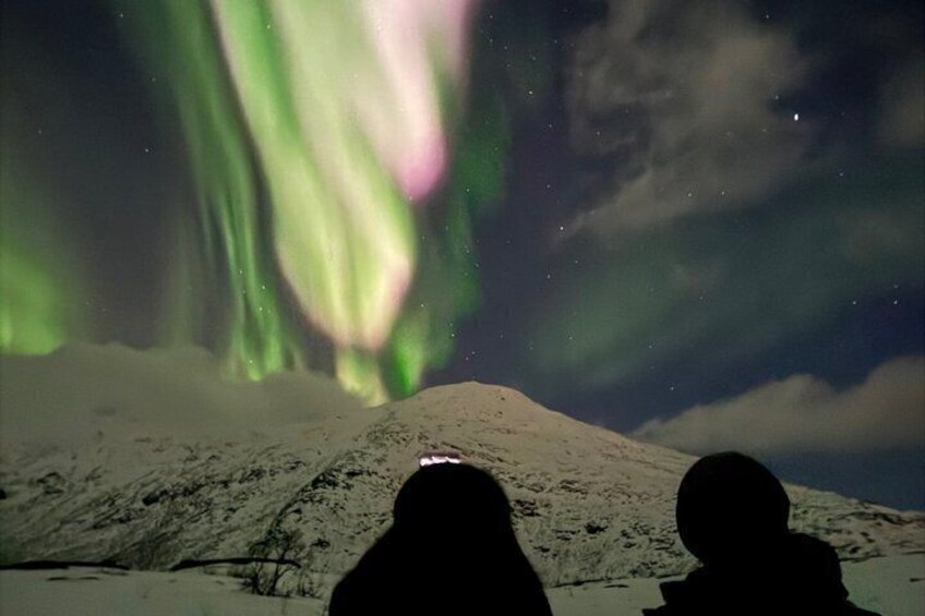 Una montaña nevada con la aurora boreal al fondo. 5