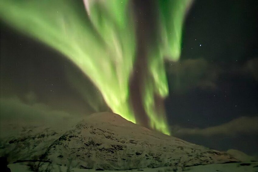 Una montaña nevada bajo una exhibición de aurora verde. 4
