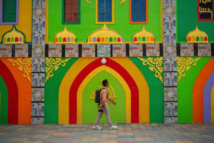 A colorful building facade with a person walking in front. 3
