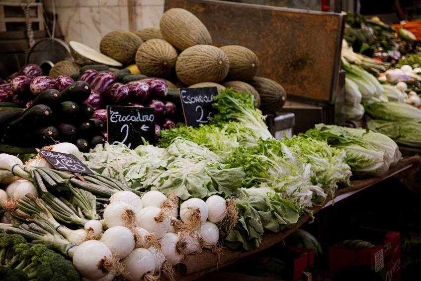 A variety of fresh vegetables on display at a market, including broccoli, cauliflower, and leafy greens. 5