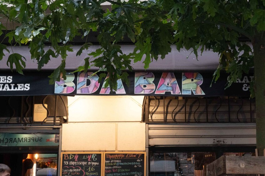A bar with a colorful sign and a chalkboard menu. 2