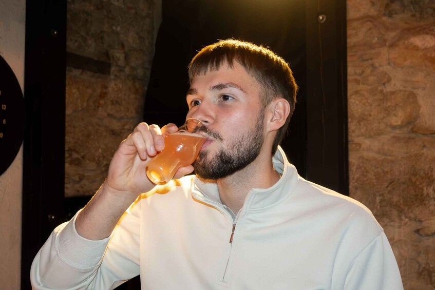 A person wearing a white jacket drinking from a glass. 3