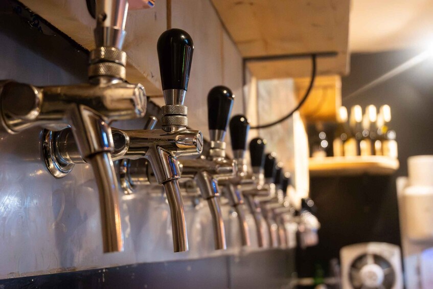 A row of beer taps with black handles. 5