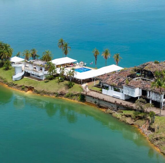 A coastal property with a swimming pool, white buildings, and palm trees. 4