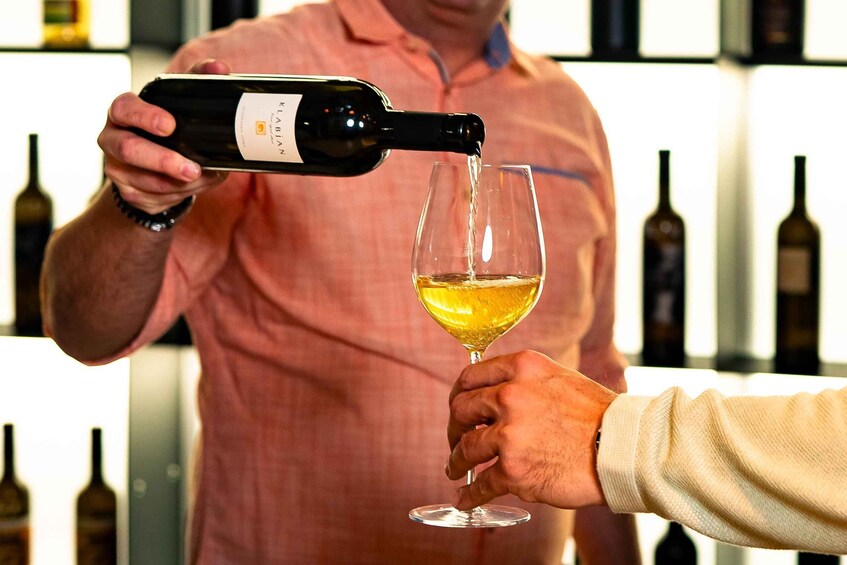A person pouring wine into a glass held by another person. 5