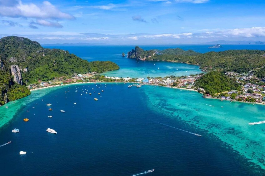 A coastal town with clear turquoise waters, boats, and lush green hills. 3