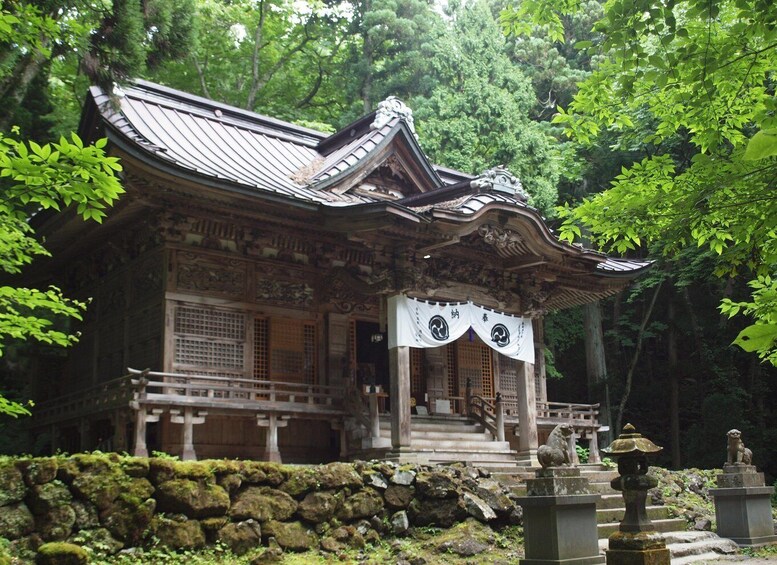 A traditional Japanese temple with ornate architecture, surrounded by lush greenery. 4
