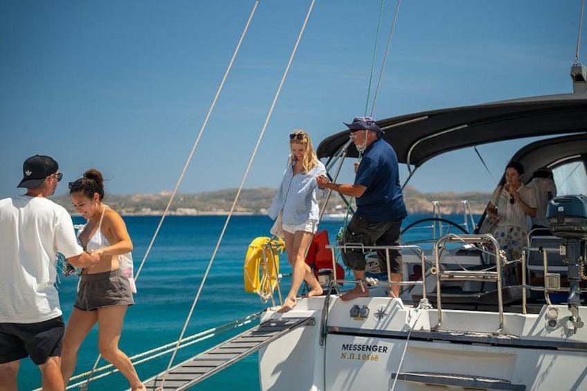 People on a sailboat with a clear blue sky and calm sea. 4