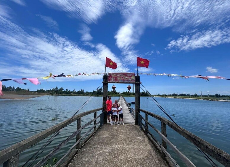 A wooden bridge with flags, a clear sky, and a calm body of water. 5
