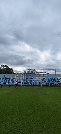 A soccer field with blue stadium seating and advertisements. 2