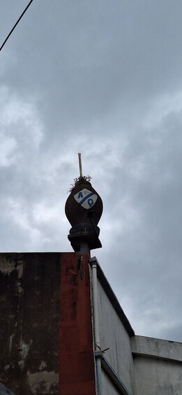 A weather vane atop a building with a red and white facade. 4