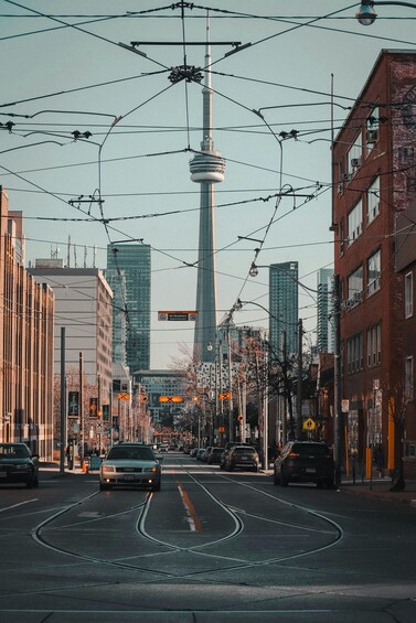 A city street with tram tracks, vehicles, and buildings. 2