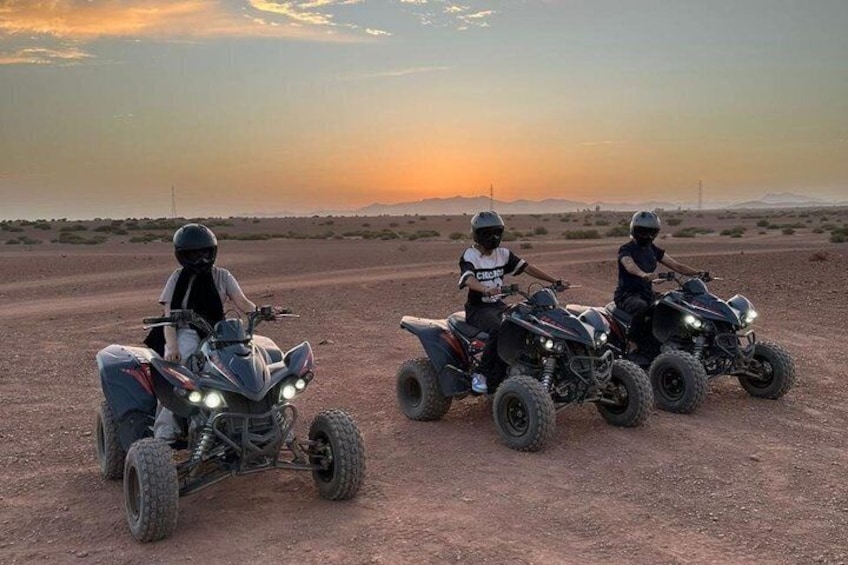 Three quad bikes on a dirt road with a sunset in the background. 5