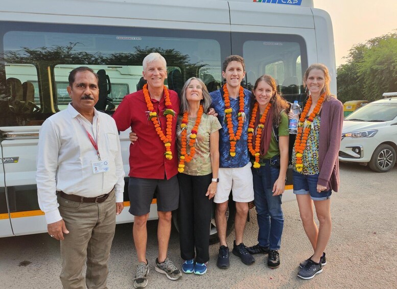 A group of people standing in front of a bus with emergency exit signs. 3