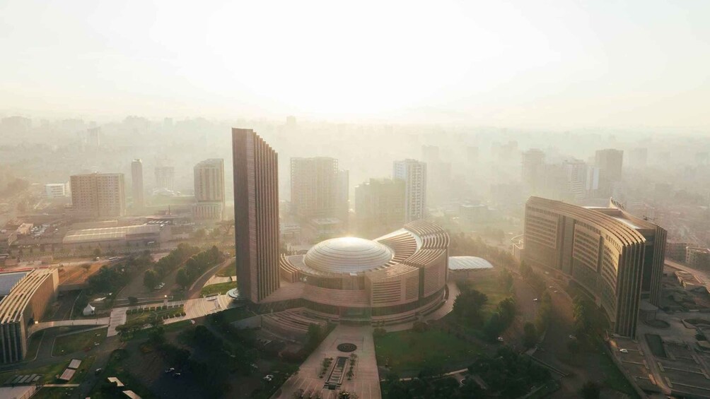 A cityscape with a prominent circular building surrounded by high-rise structures. 5