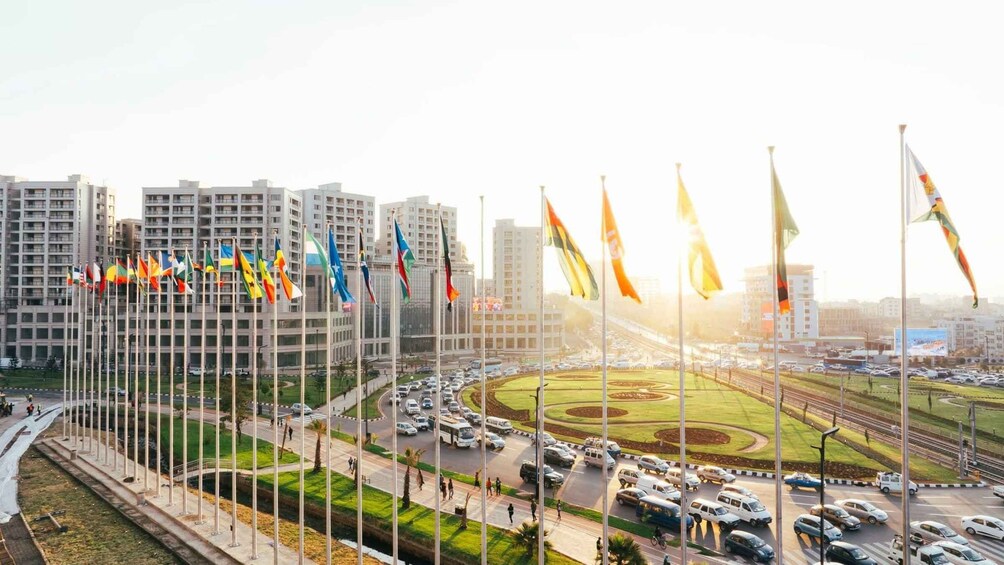 A cityscape with multiple flags, a roundabout, and modern buildings. 1