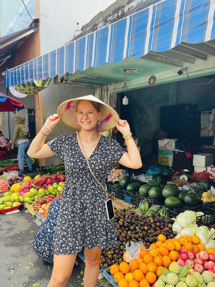 A person at a fruit market with various fruits and vegetables on display. 4