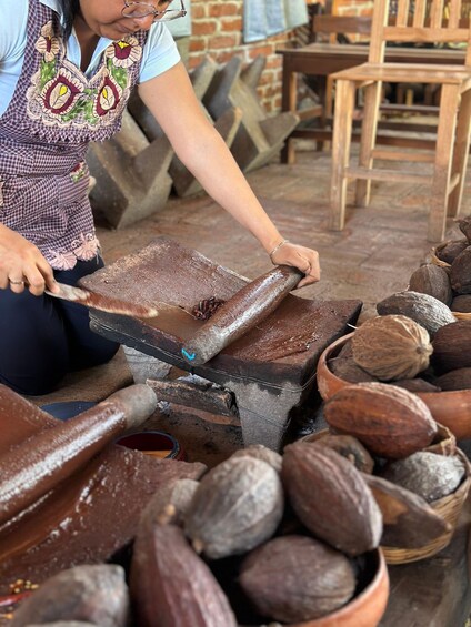 A person cutting a large piece of wood with a knife. 1