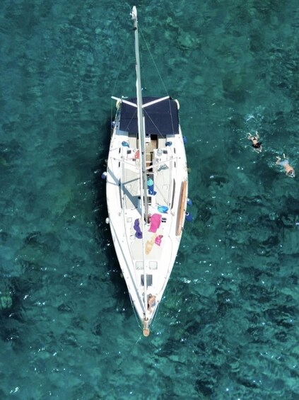 A sailboat with a person swimming nearby. 3