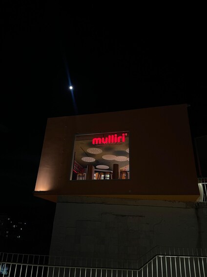 A modern building with a prominent red sign reading 'mullii'. 3