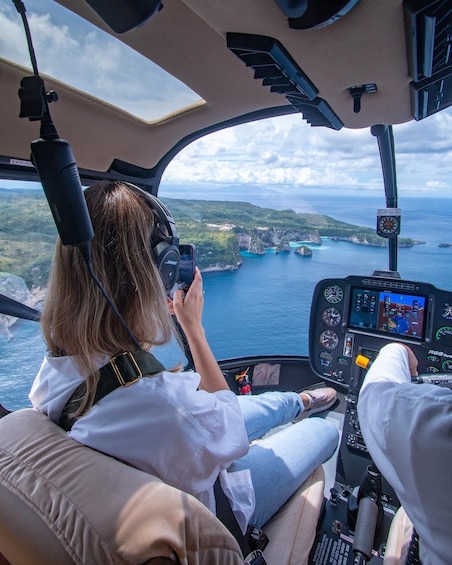A helicopter cockpit with a view of a coastline and water. 3