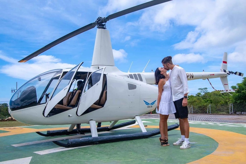 A helicopter with 'VOLTA' branding on the side, parked on a helipad with a clear sky in the background. 1