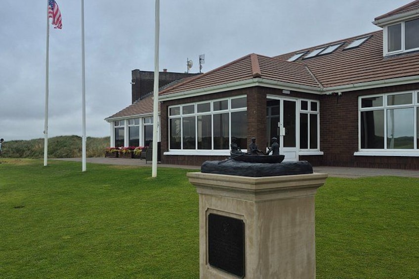 A building with large windows, a flagpole with an American flag, and a fountain. 2