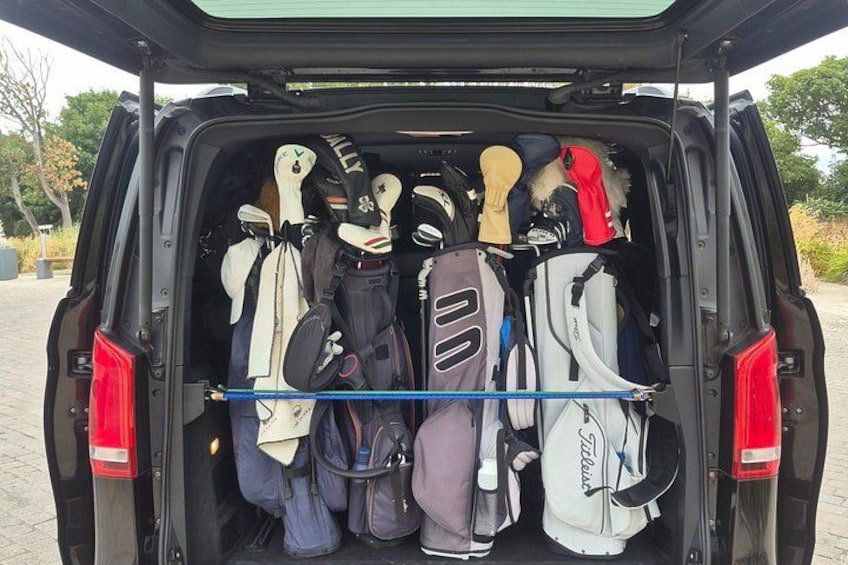 A vehicle's trunk filled with various golf bags and equipment. 3