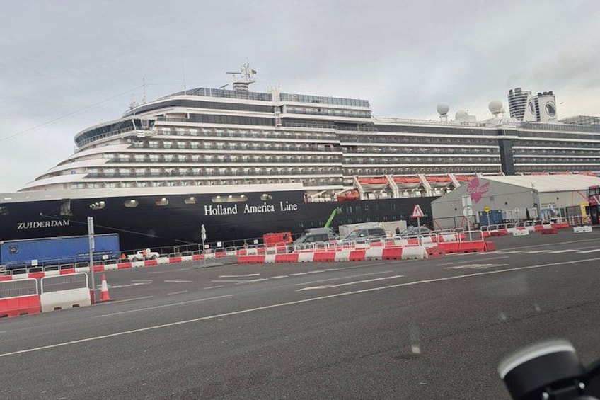 A large cruise ship docked at a port with a terminal building in the background. 5
