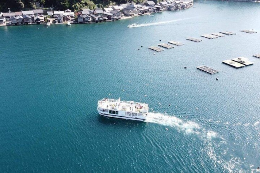 A boat on a turquoise body of water with a docked pier in the background. 4