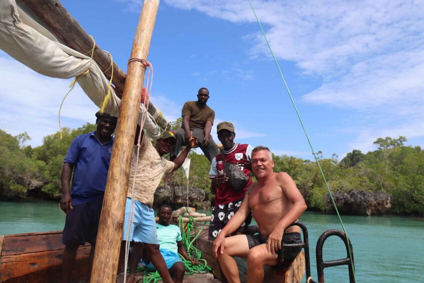 A group of people on a boat with a forested shoreline in the background. 4